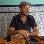 Stacco sentado en una mesa con las manos cruzadas.